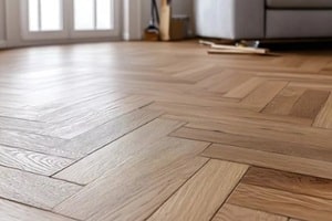 carpenter installing wooden flooring in a living room
